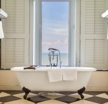 Luxury bathtub with relaxing ambient window with scenic sea vie