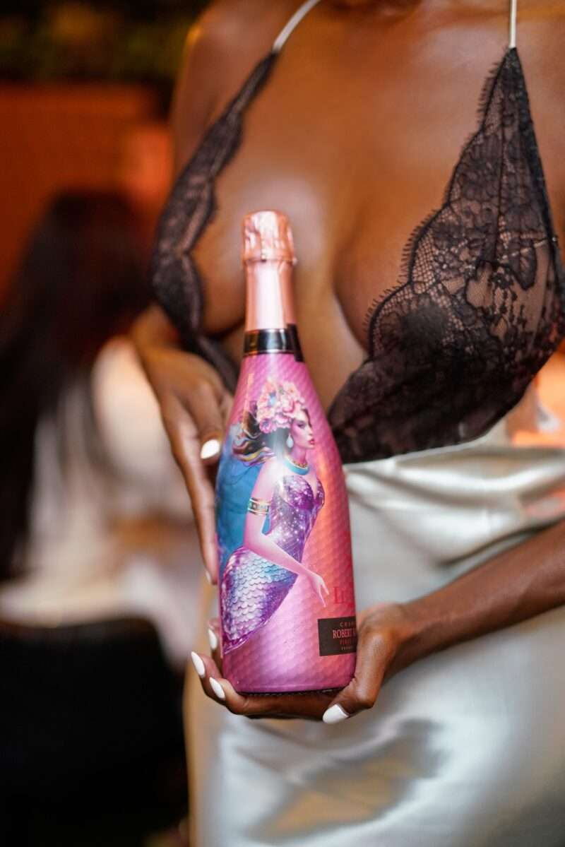 Guest holding a bottle of Le Kool Champagne